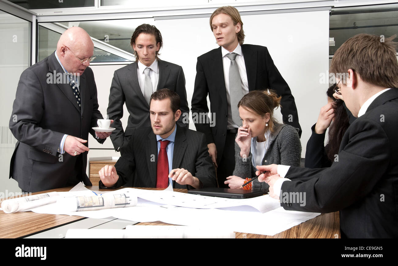 Un amministratore di una società e il suo team a discutere piani durante un incontro di office Foto Stock