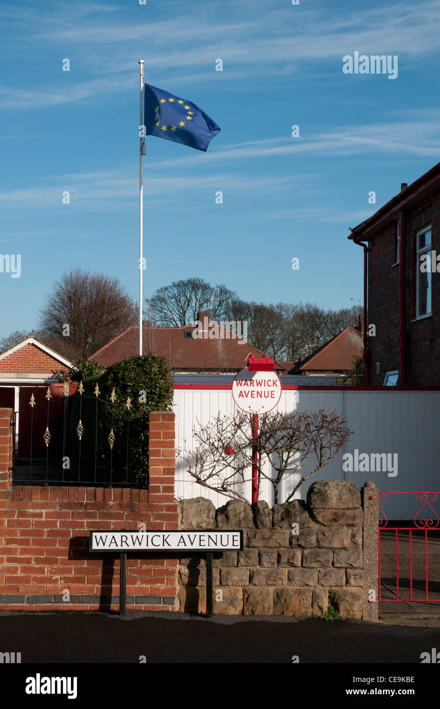 Bandiera dell'Unione europea in volo da un pennone in un tipico sobborgo inglese Foto Stock