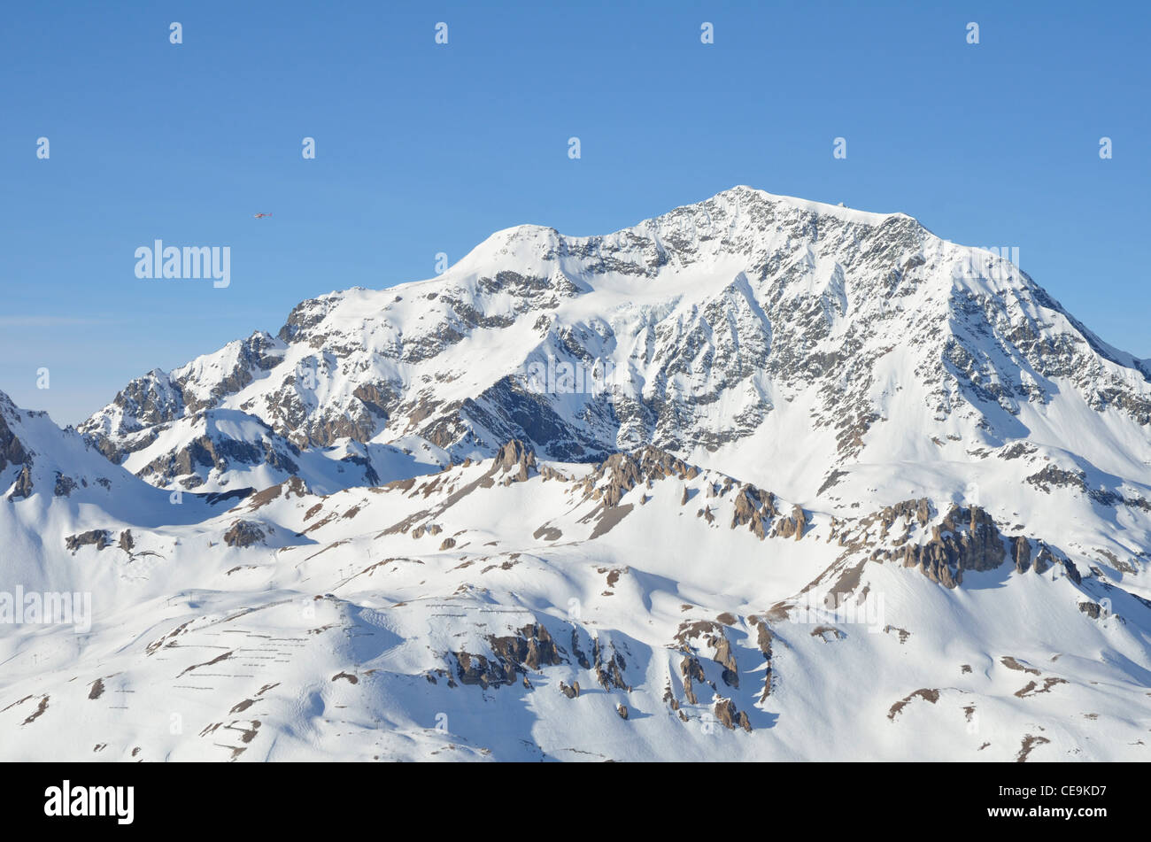 Coperta di neve montagna, cielo blu, rosso distanti elicottero, Tignes della Vanoise, Alpi,Savoire, Francia,l'Europa Foto Stock