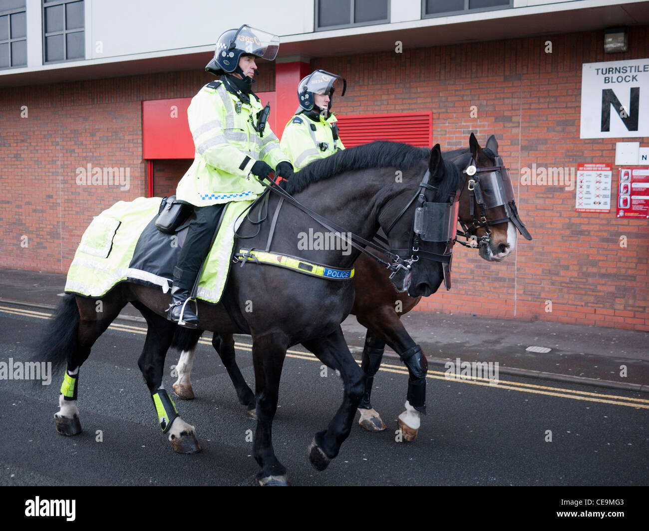 I cavalli della polizia e la polizia montata al di fuori di Anfield football club Liverpool England Regno Unito Foto Stock