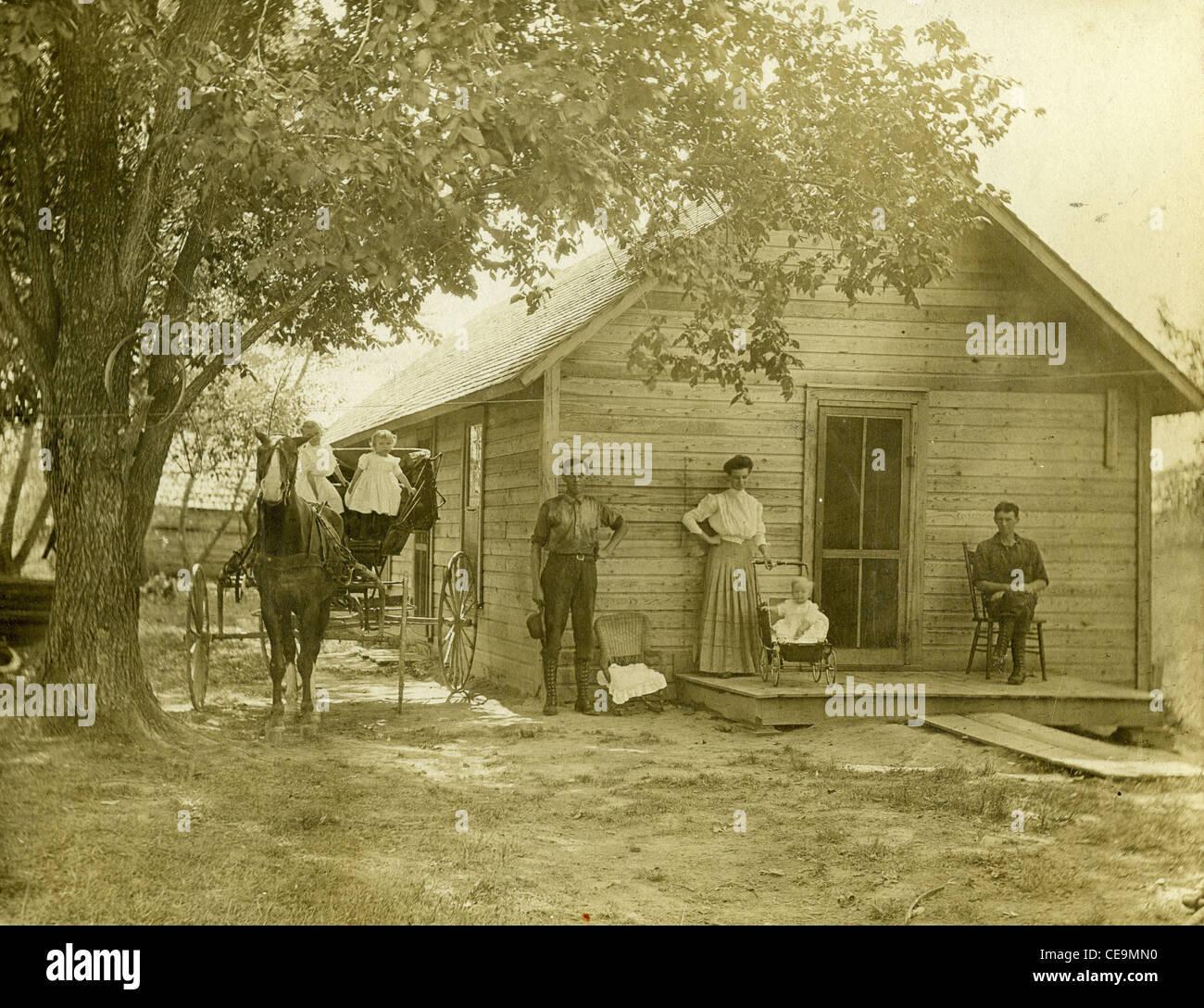 Homesteaders con cavallo e buggy in piedi di fronte a casa in legno nel 1916 Illinois pionieri agricoltori midwest homestead vintage foto di coloni di stile di vita Foto Stock
