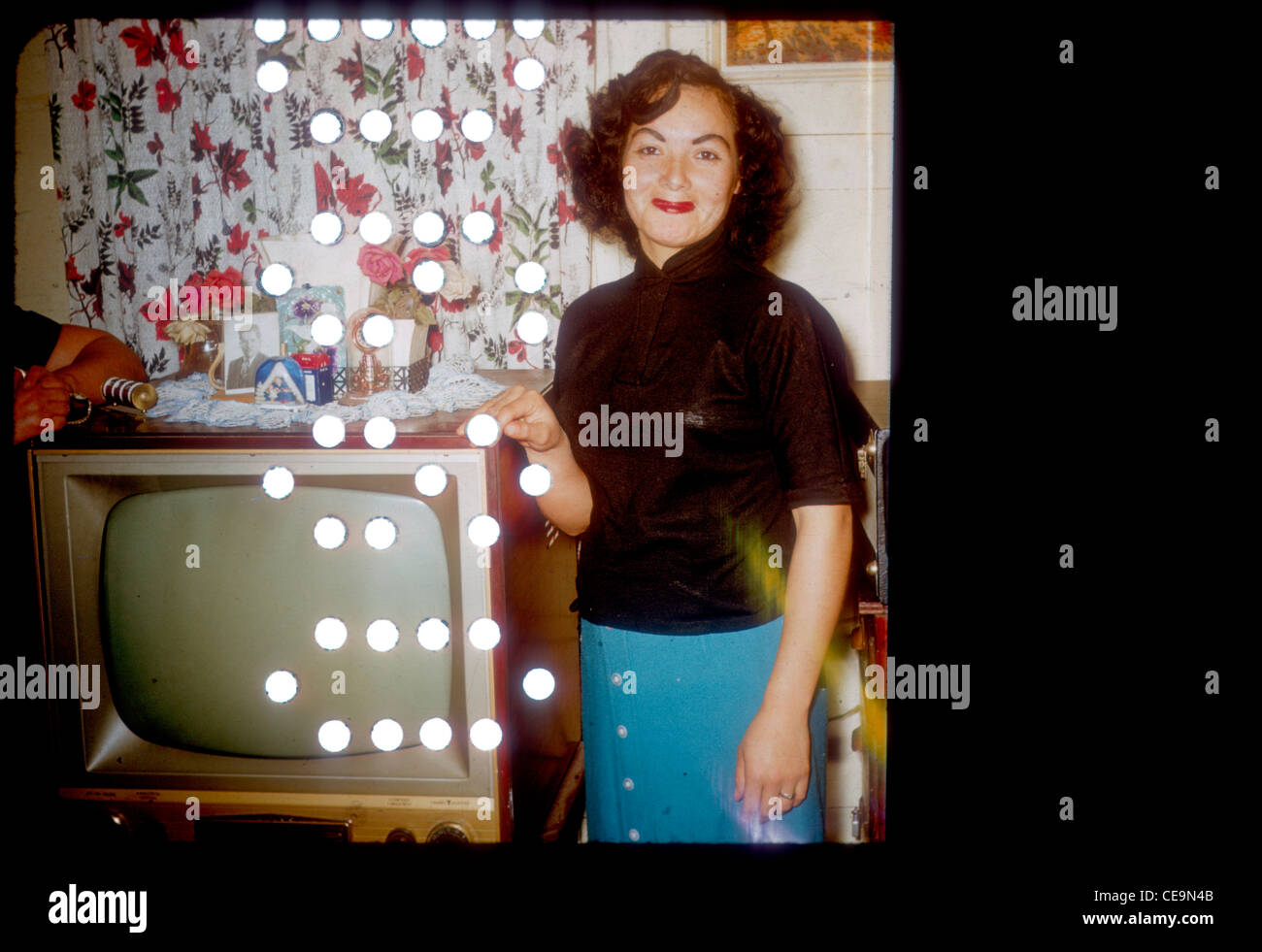 Messicano Fasionable donna americana in piedi accanto alla televisione durante i primi anni sessanta. televisione latino Foto Stock