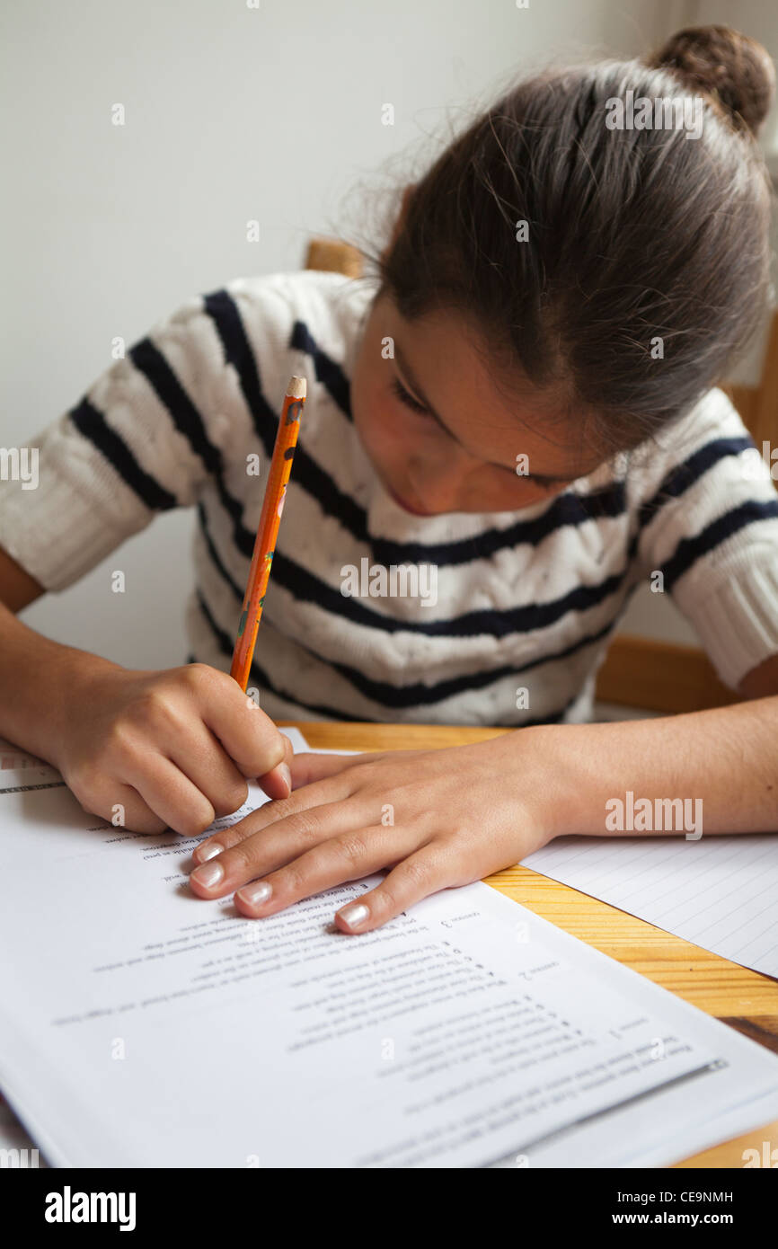 Giovane ragazza di completare i suoi compiti a casa da solo Foto Stock