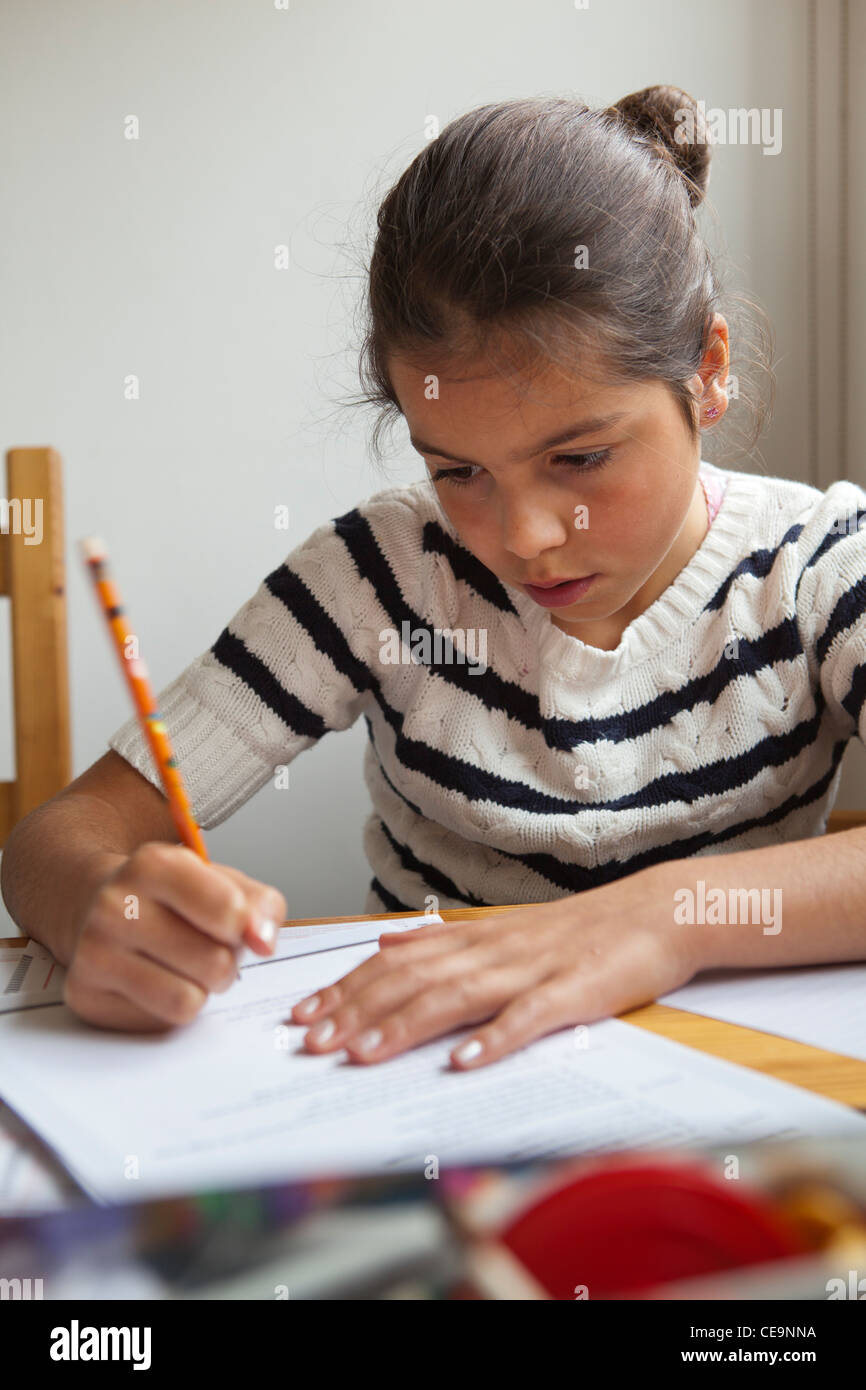 Giovane ragazza di completare i suoi compiti a casa da solo Foto Stock