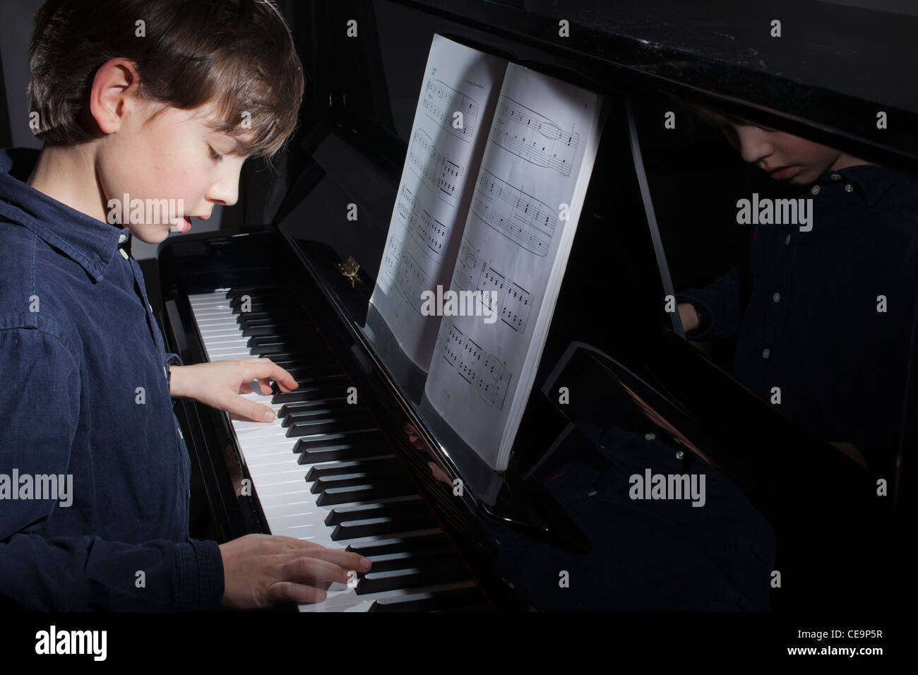 Ragazzo,10 anni,suona il pianoforte a casa Foto Stock