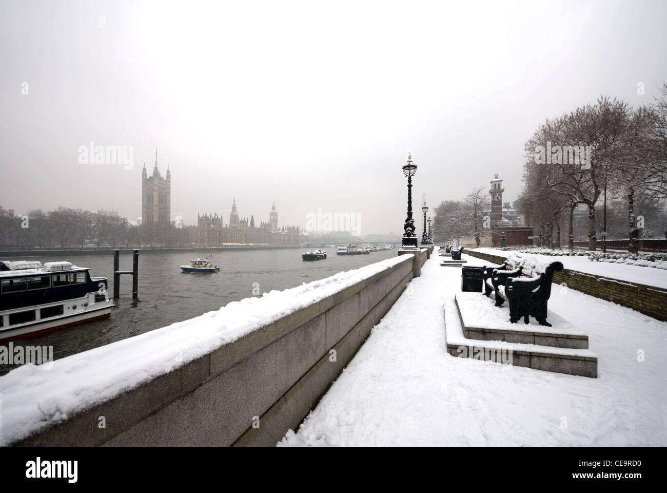Una vista del fiume Tamigi e il Big Ben, catturare da un passaggio pedonale adiacente al fiume, su un freddo, nevoso, Winter's day Foto Stock