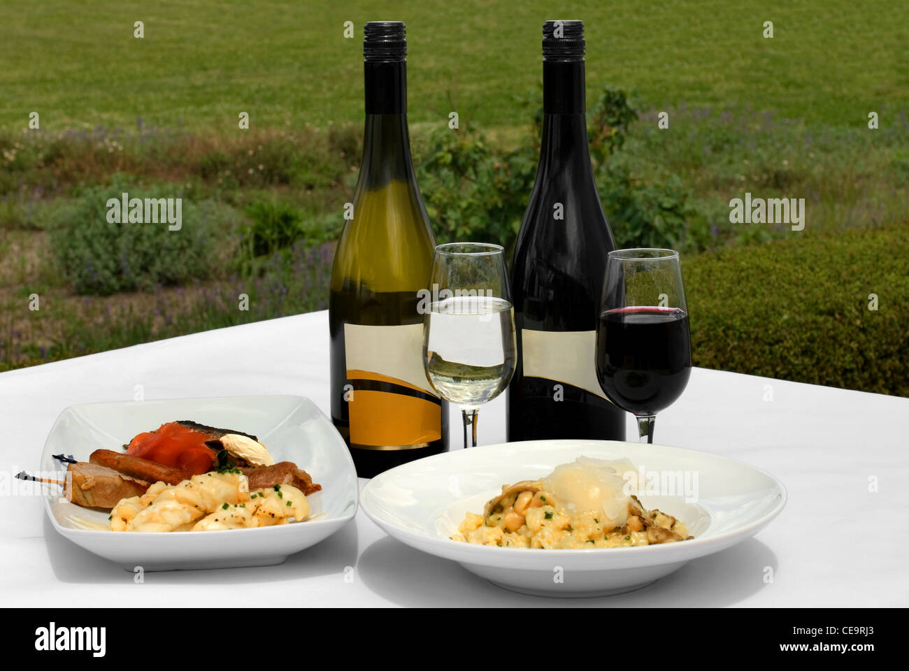 Un antipasto per la piastra di degustazione e una ciotola di Risotto ai funghi, accompagnato da un bicchiere di Chardonnay Foto Stock