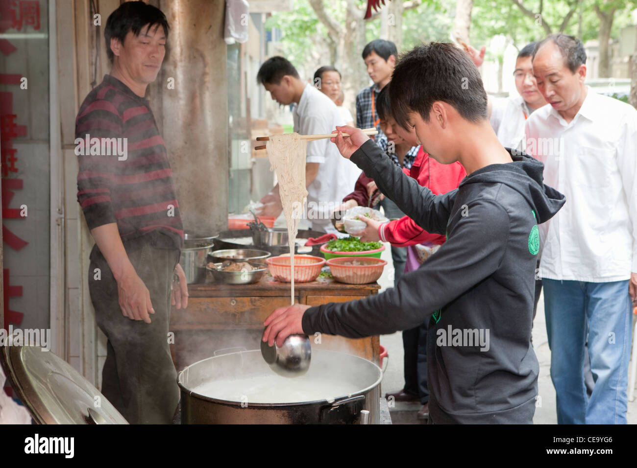 Ragazzo che serve noodles; concessione francese; Shanghai; Cina Foto Stock