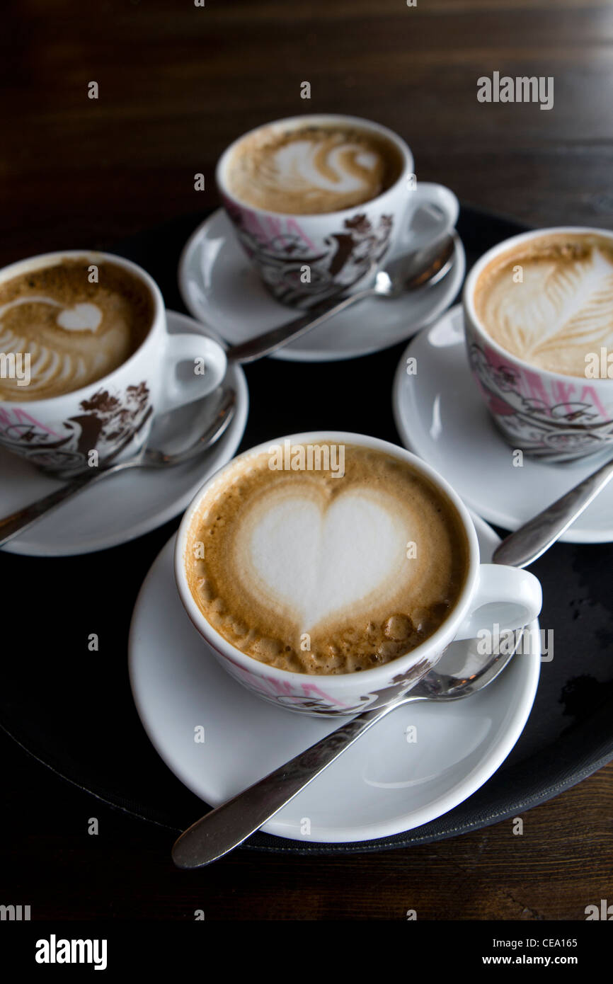 Quattro tazze cappuccino a quindici, Cornwall con arte in schiuma Foto Stock