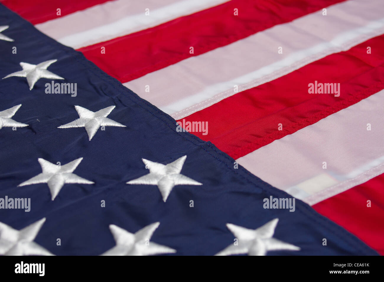 Una bandiera americana imposta diagonalmente attraverso il telaio. Il campo blu in primo piano a sinistra con le strisce in sfondo a destra Foto Stock