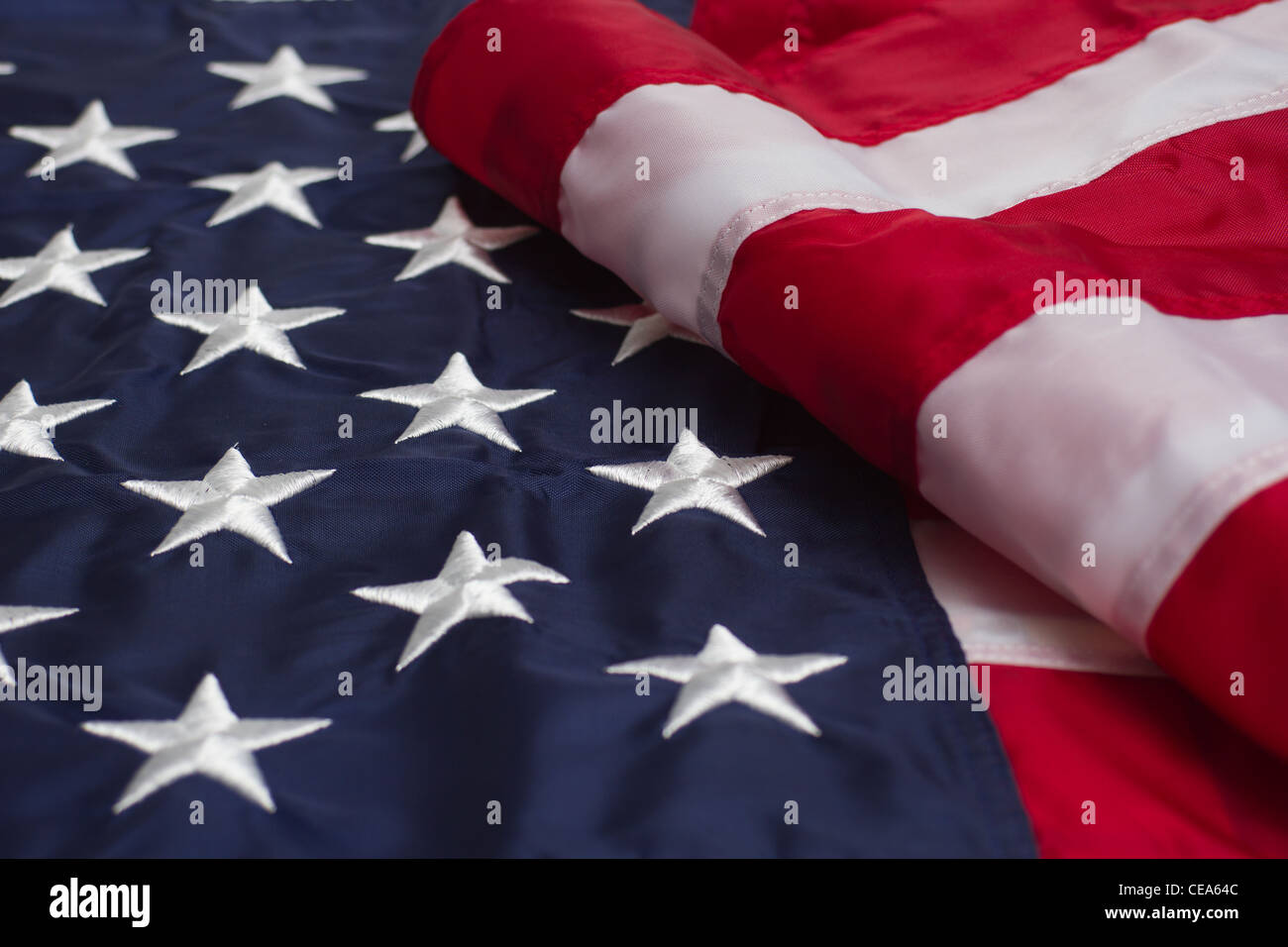 Una bandiera americana parzialmente piegato. Il campo delle stelle è predominano sulla sinistra con le strisce a destra. Foto Stock