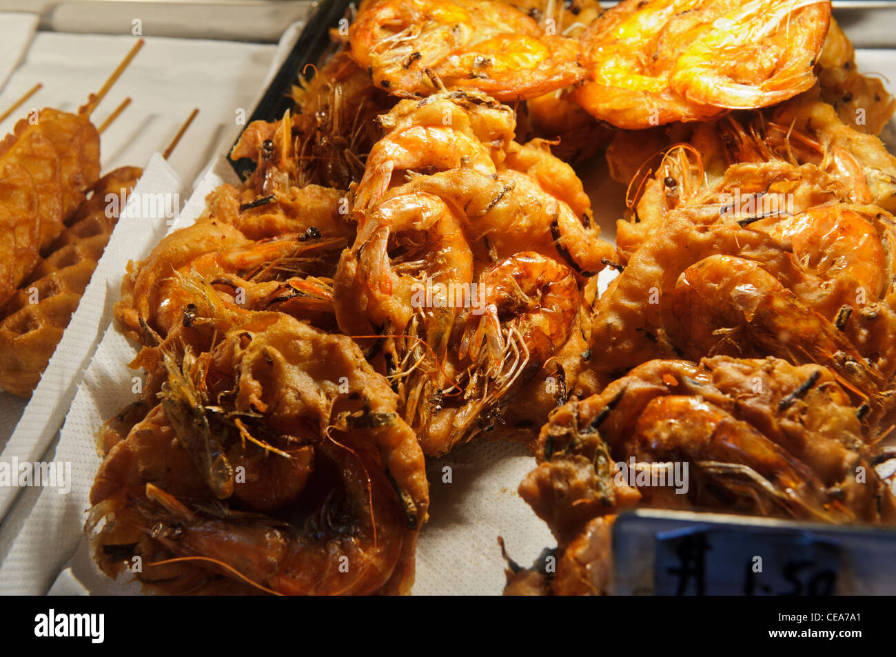 Cuocere i gamberi cracker in vendita presso un food court, Singapore. Foto Stock