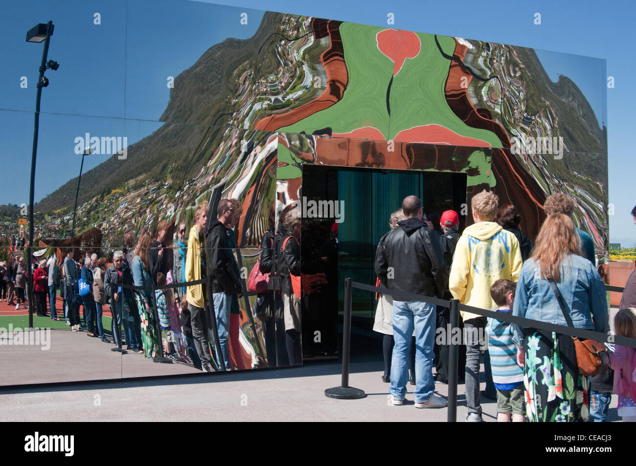 I visitatori in coda per entrare la Mona art museum sul fiume Derwent, Hobart, vengono riflesse nel vetro dello specchio. Foto Stock