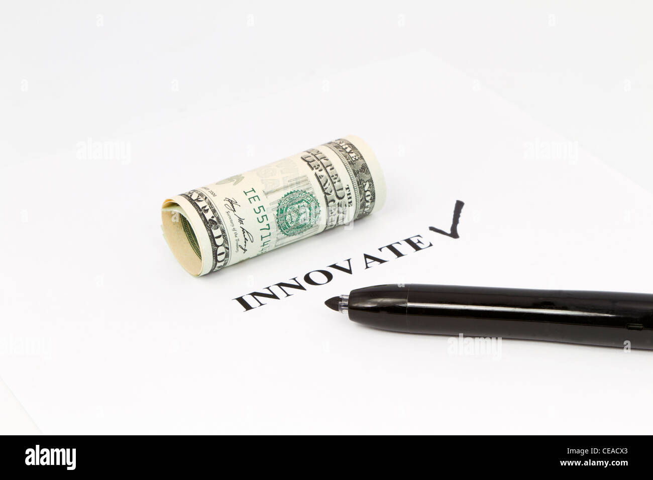 La parola, innovare è stampato in nero con un segno di spunta accanto ad essa e laminati valuta statunitense di cui sopra. Foto Stock