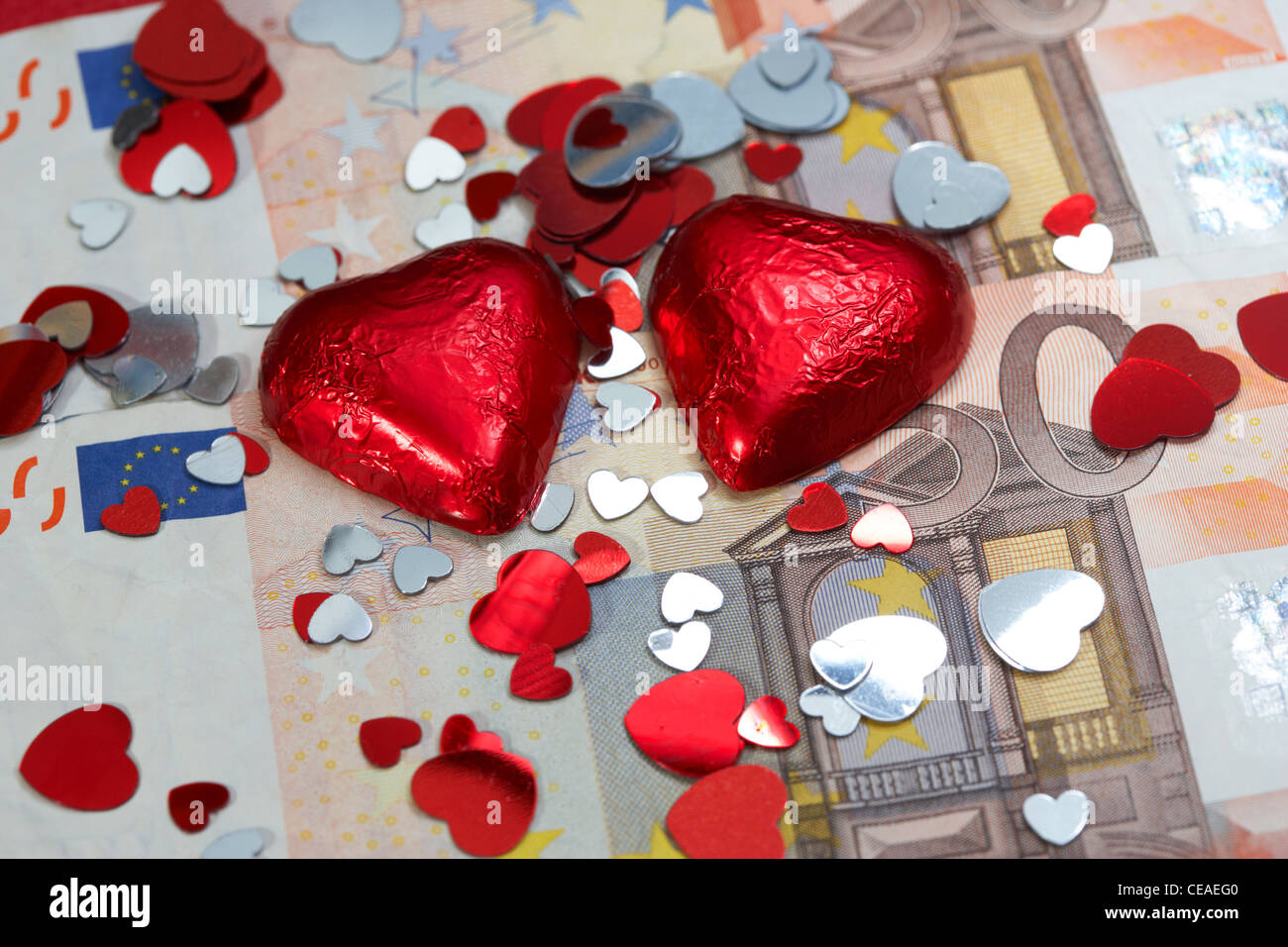 Cuori di cioccolato e decorazioni su euro in contanti Foto Stock