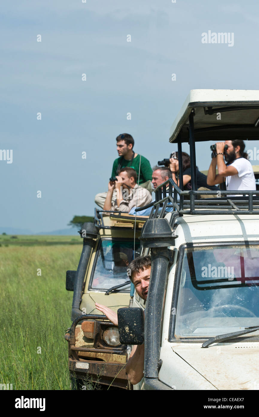 Turismo a guardare la fauna selvatica da loro vetture a Kopjes Masai nel Serengeti, Tanzania Foto Stock