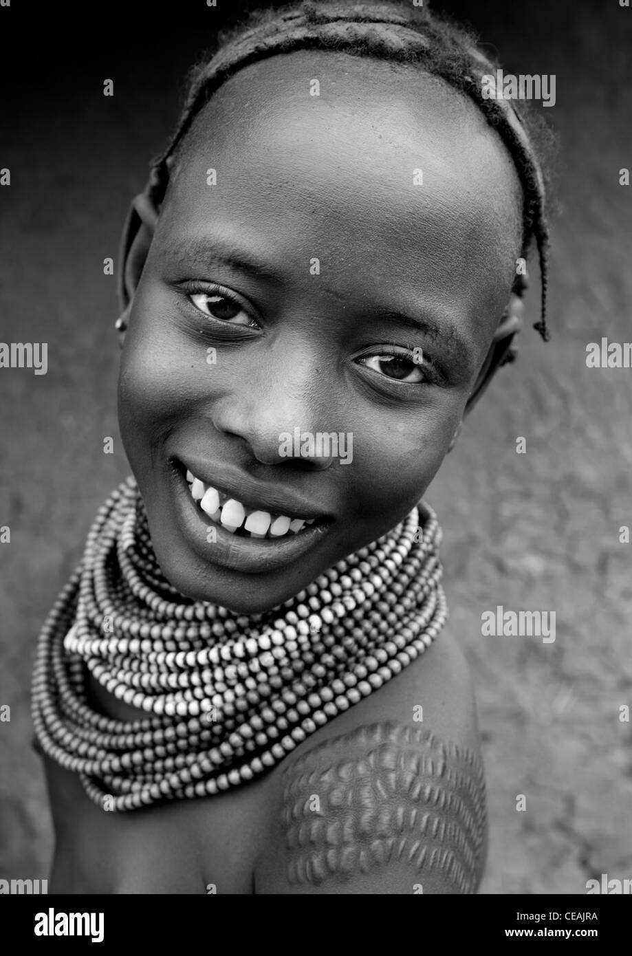 Giovane ragazza Dassanech con Scarified spalla e collane di perle sorriso ritratto Omorate Etiopia Foto Stock