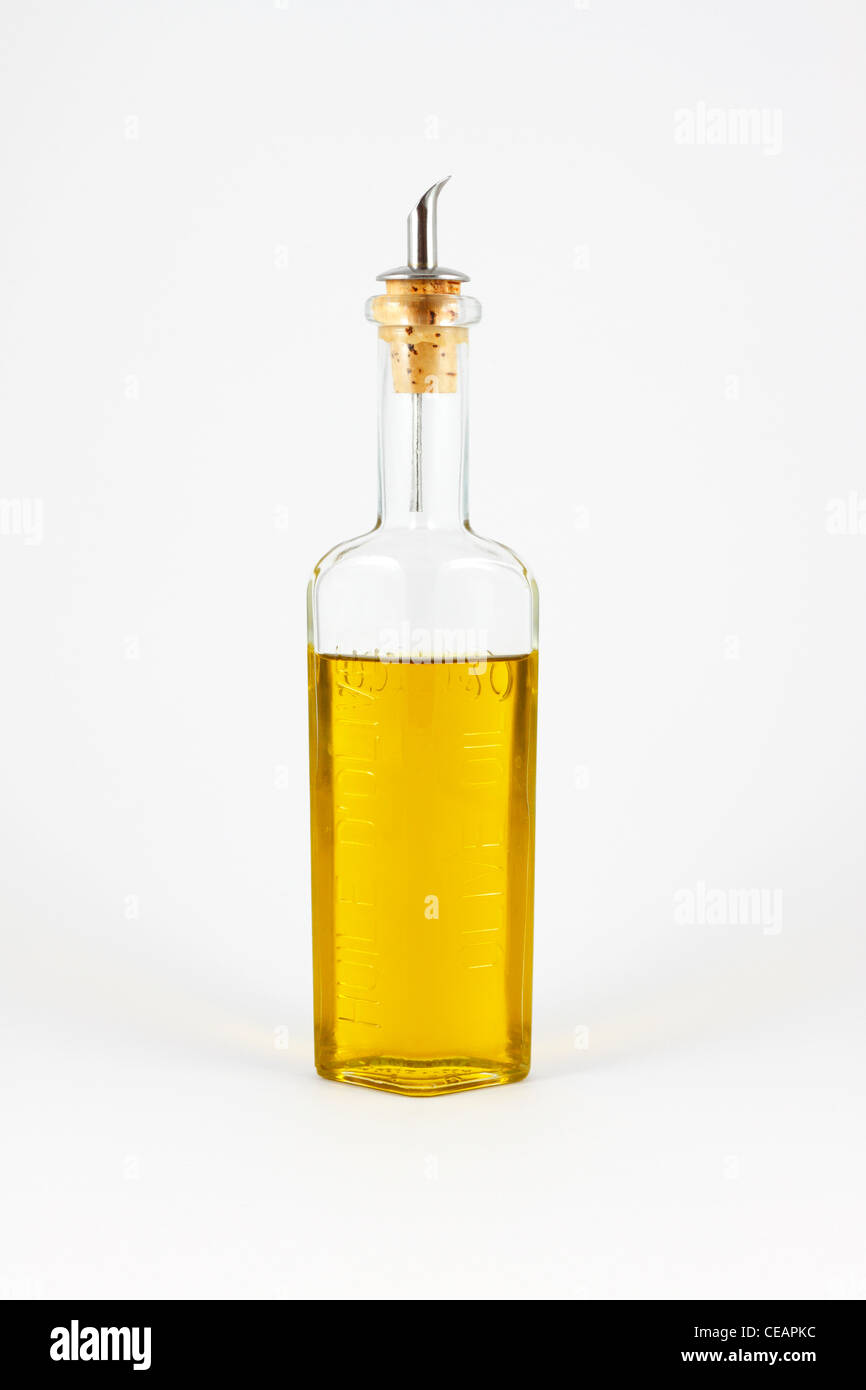 Olio di oliva in una bottiglia di vetro con un versatore su sfondo bianco. Foto Stock