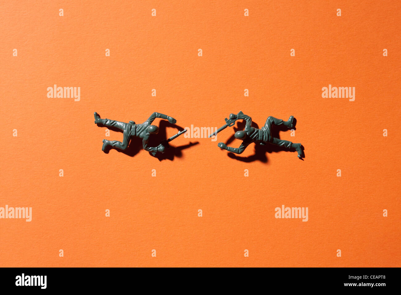 Due soldati giocattolo su sfondo arancione Foto Stock
