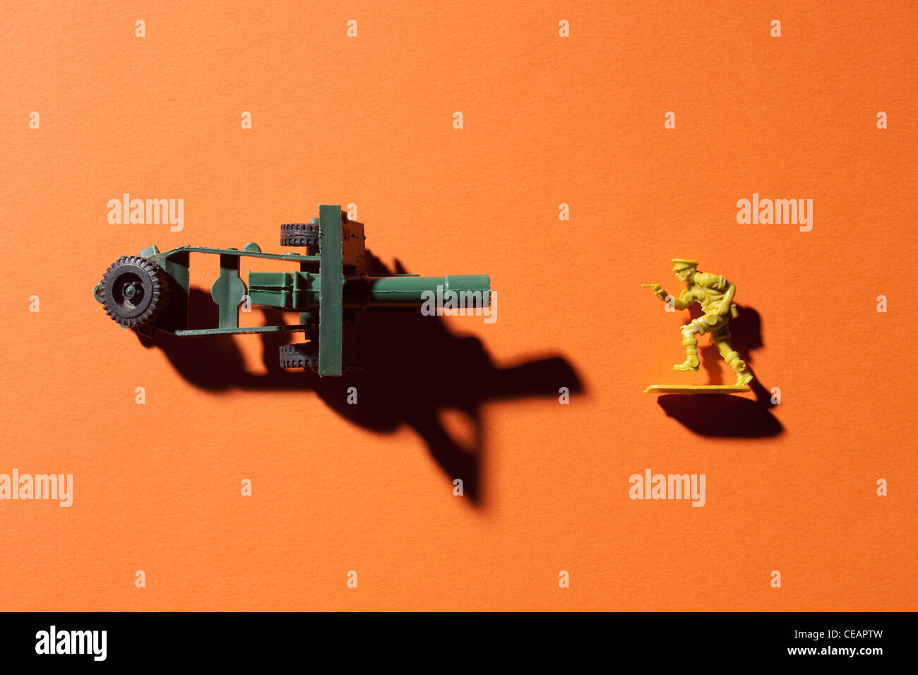 Soldatino e canon su sfondo arancione Foto Stock