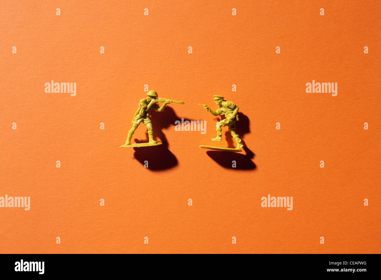 Due soldati giocattolo su sfondo arancione Foto Stock