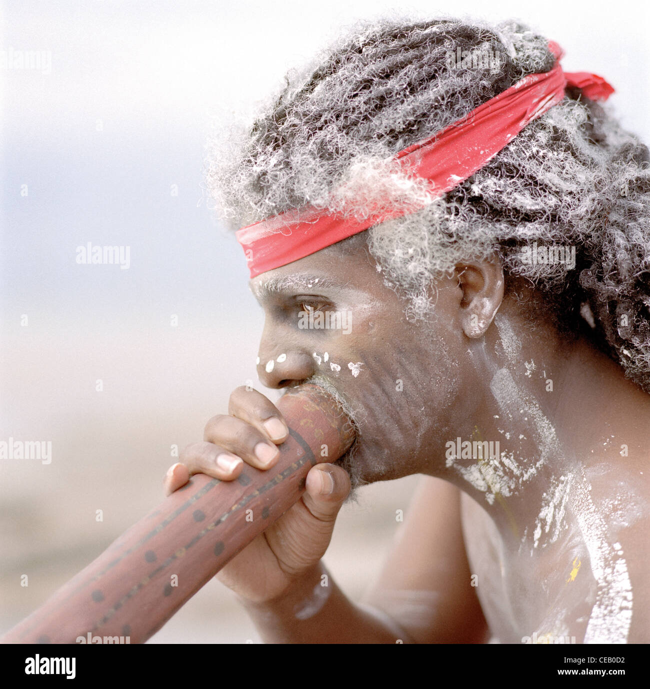 Presto l'uomo gioca un didgeridoo su una spiaggia. Foto Stock