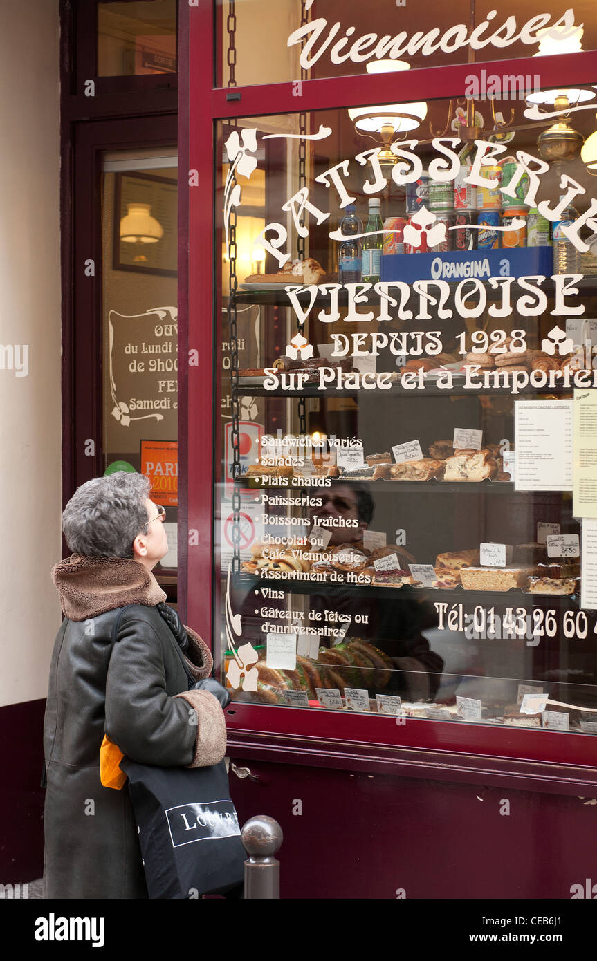 Una donna di fronte a un panettiere finestra in Montmartre, Parigi Foto Stock