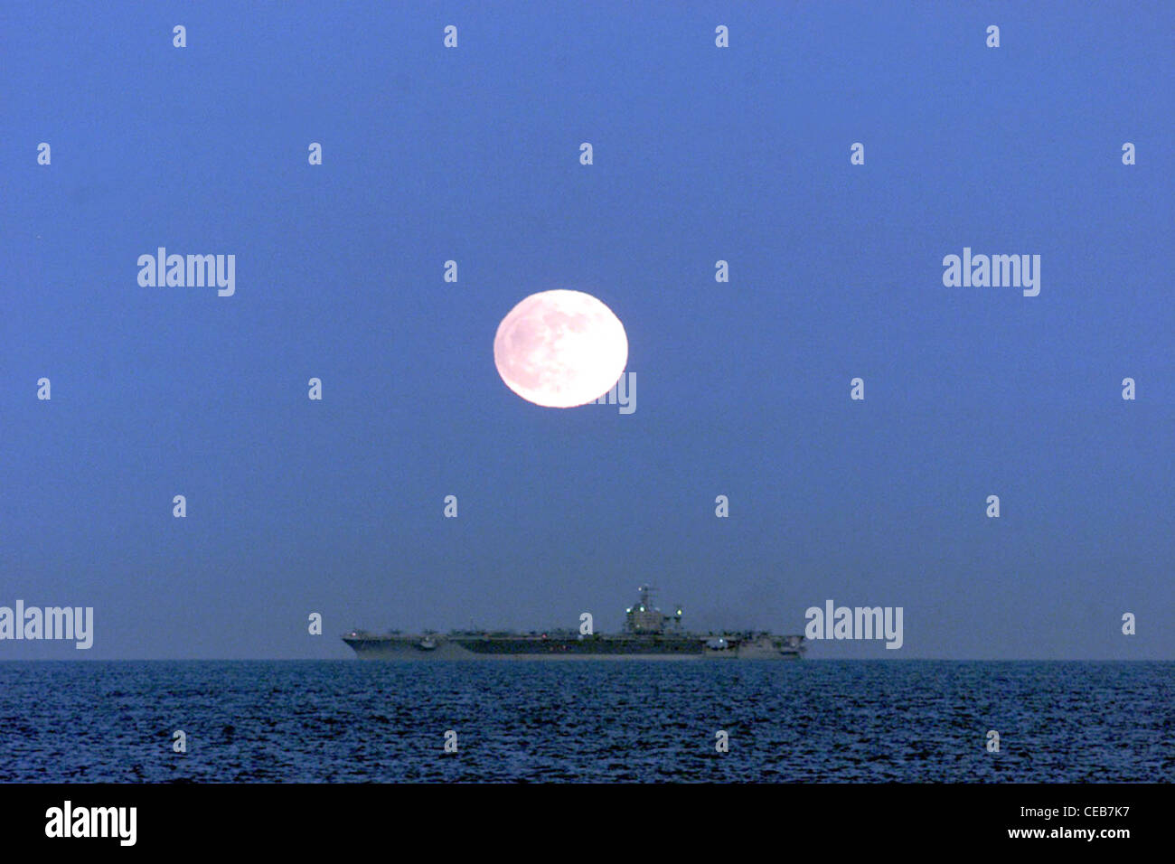 USS Carl Vinson (novembre 20 ,2002) -- come visto dal ponte della fregata missilistica guidata USS Ingraham (FFG 61), una luna piena illumina la portaerei nucleare Carl Vinson mentre si svolgono operazioni di volo notturno. Carl Vinson sta attualmente svolgendo corsi di formazione al largo della costa meridionale della California in preparazione del loro prossimo implementazione programmata. Foto Stock
