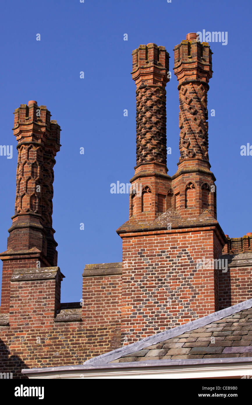 Tudor rosso mattone camini costruiti in spirali, a lisca di pesce e i modelli di idromassaggio sul tetto del Palazzo di Hampton Court Foto Stock