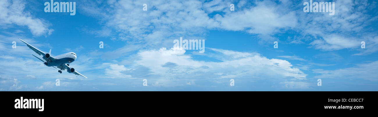 Piano di getto in un colore blu cielo nuvoloso. Composizione panoramica in alta risoluzione. Foto Stock