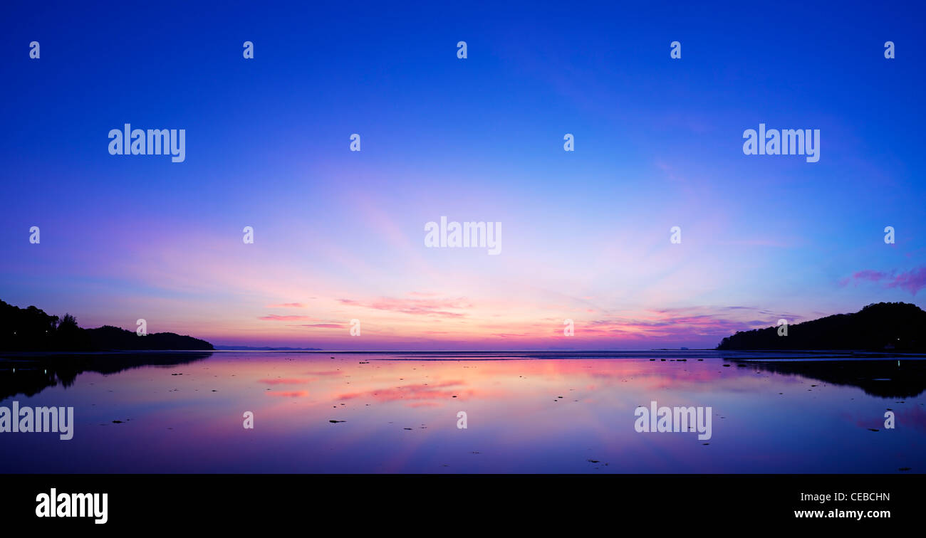 Spettacolare alba di scena a la costa orientale dell'isola di Phuket, Tailandia. Una lunga esposizione shot. Composizione panoramica. Foto Stock