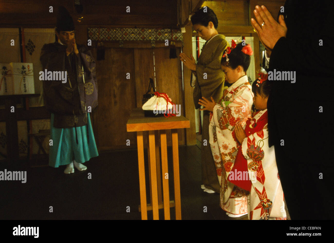 Archetti rispettoso della famiglia e il sacerdote fine un shichi-go-rituale san all'interno dell'Aoto jinja sacrario in Tokyo, Giappone Foto Stock