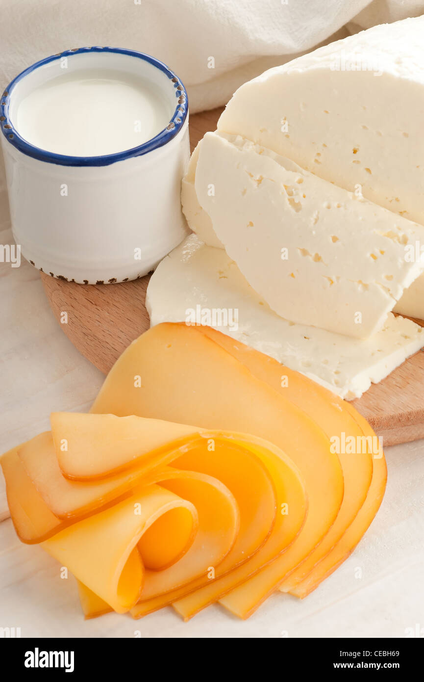 La prima colazione con il latte e il formaggio su un vecchio tavolo di legno con tovaglie di lino Foto Stock