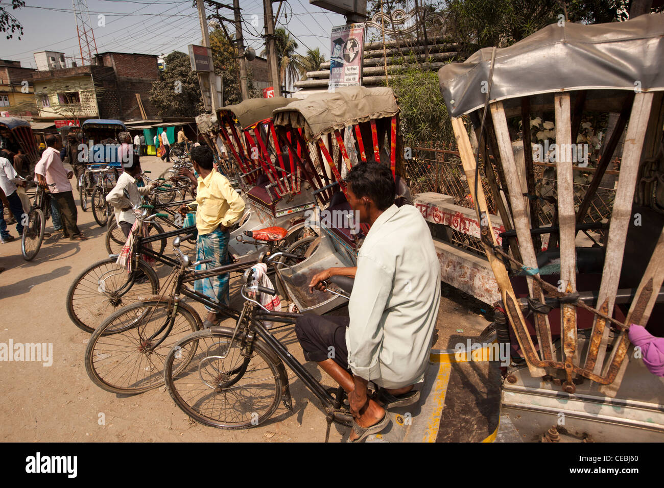India, Assam, Mangaldai, MG Road, ciclo rickshaw wallahs in attesa di clienti presso il nodo stradale Foto Stock
