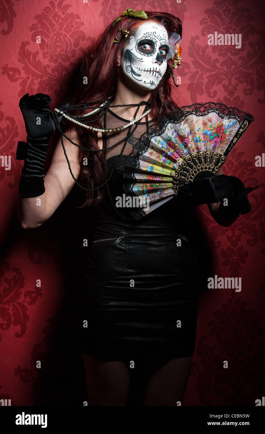Una donna con il suo volto dipinto come un tradizionale giorno dei morti sugarskull mask Foto Stock