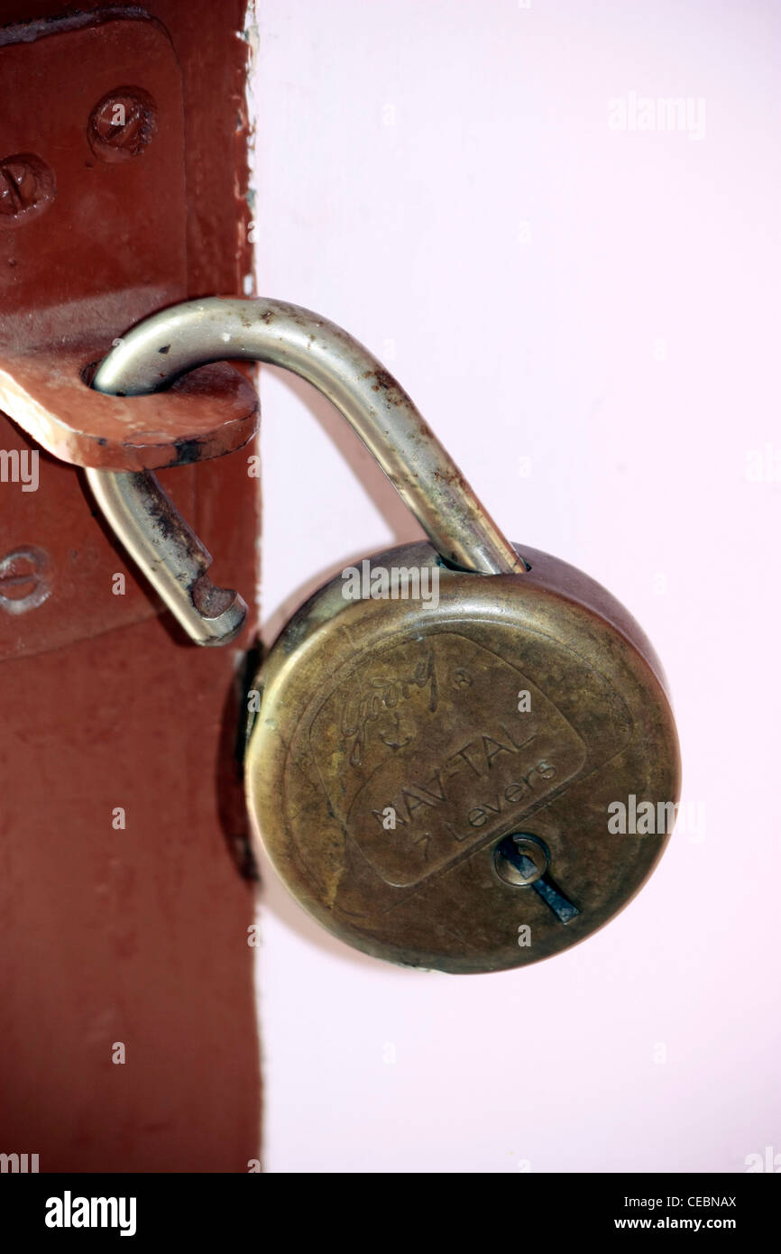 Una vecchia serratura arrugginita appesa al gancio nel muro della porta Foto Stock