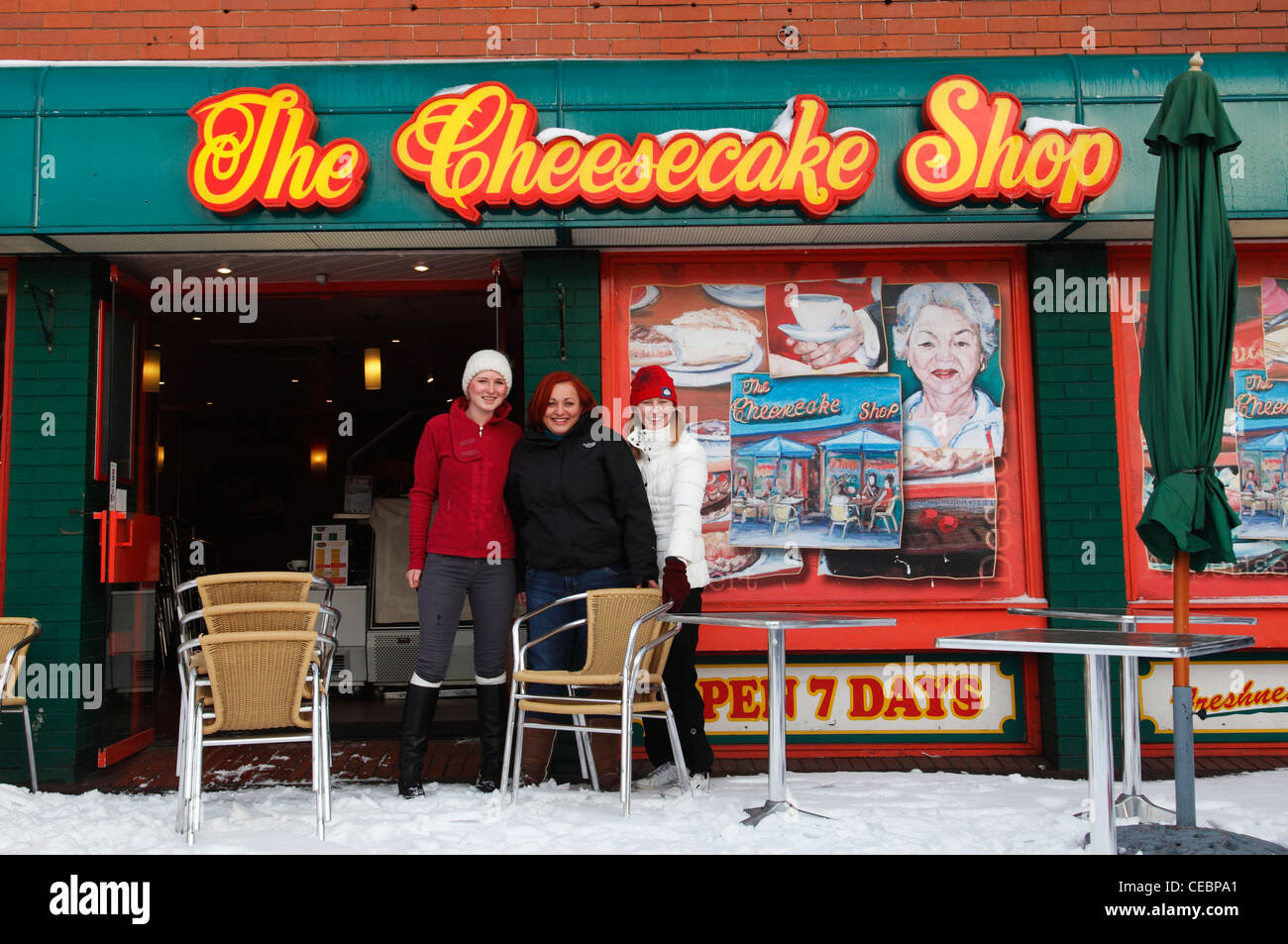 I dipendenti di disporre tavoli e sedie in neve a cheese-cake Shop, Mapperley Plains, Nottingham, Inghilterra, Regno Unito Foto Stock