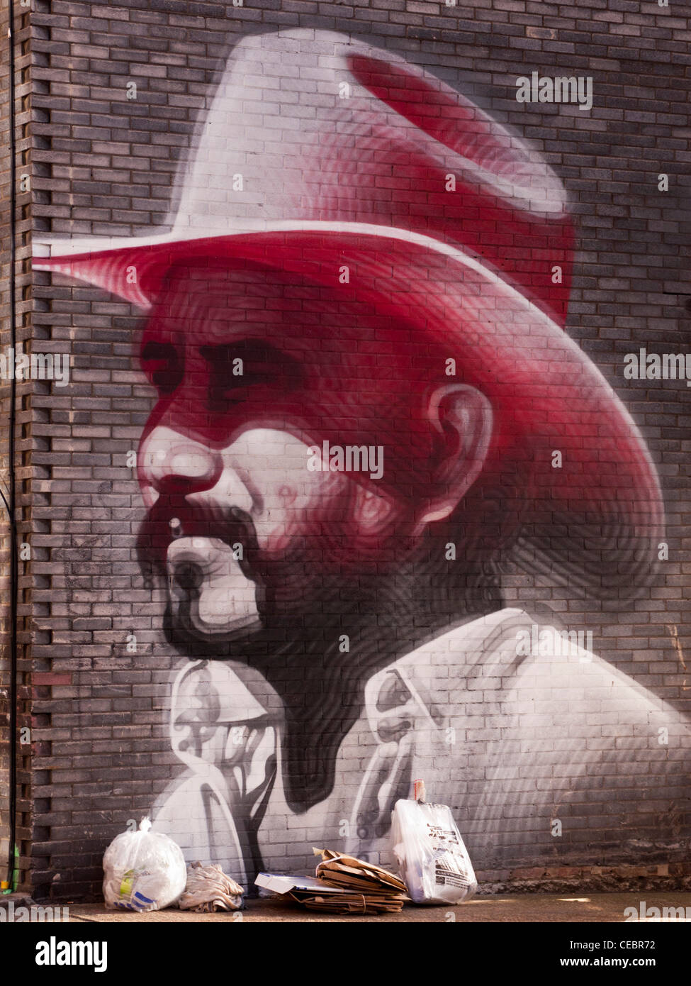 Arte di strada di una principale che indossa un cappello da cowboy nella zona est di Londra, Inghilterra Foto Stock