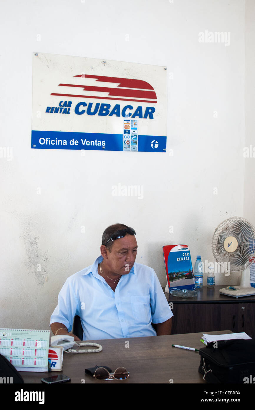 Società di noleggio auto in Cuba, lavoratore presso la scrivania in attesa per i clienti Foto Stock