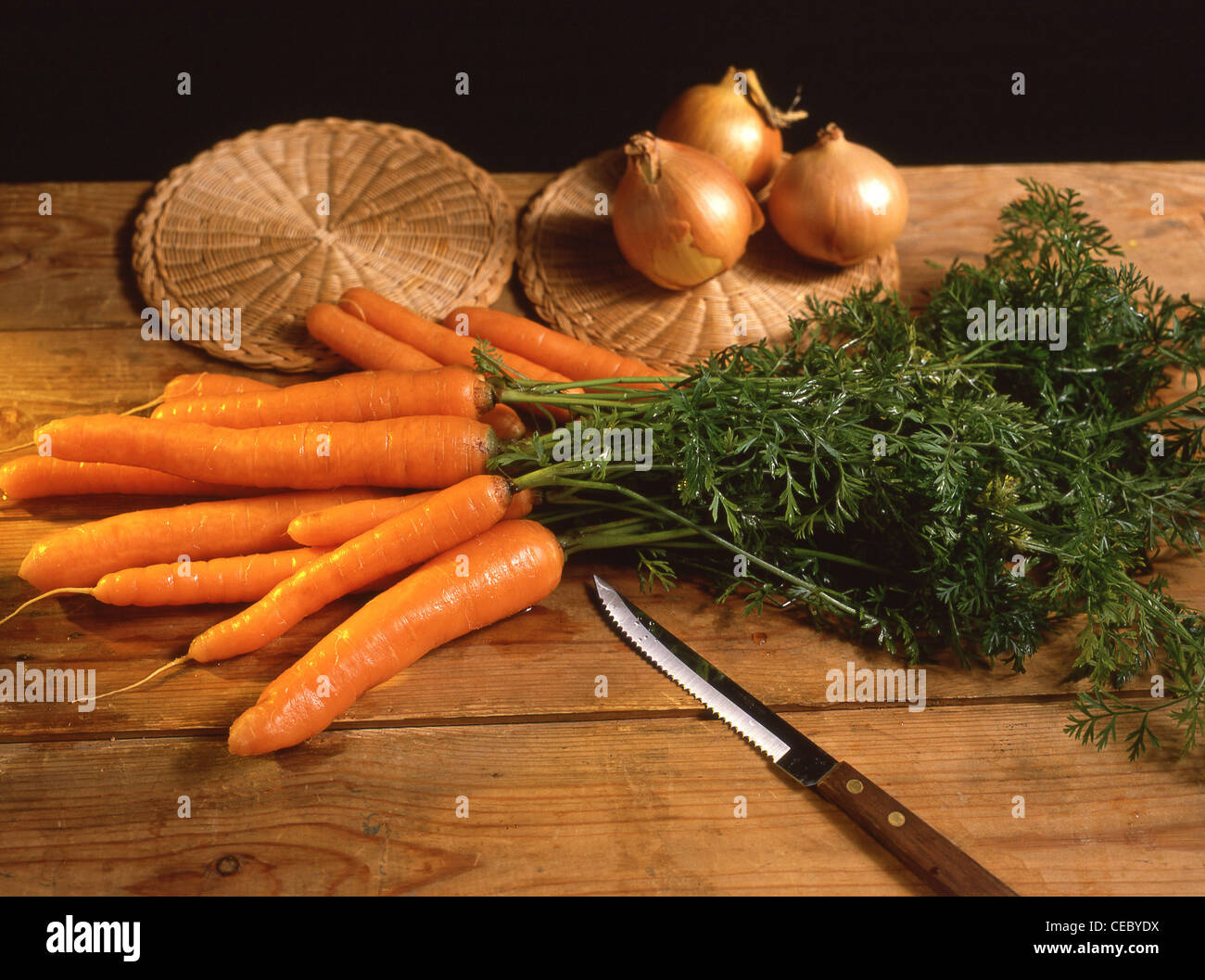 Le carote con piccioli sul blocco di trinciatura, Berkshire, Inghilterra, Regno Unito Foto Stock