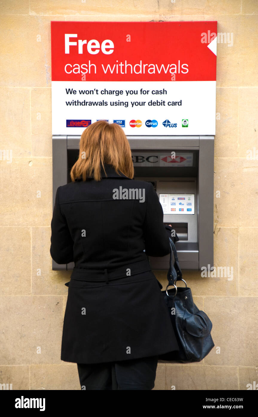 Donna con borsetta in nero al bancomat ATM della macchina Foto Stock