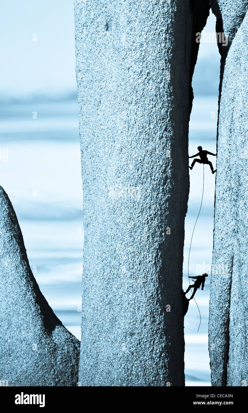 Team di alpinisti lotta fino per la successiva presa sulla loro ascesa al vertice. Foto Stock