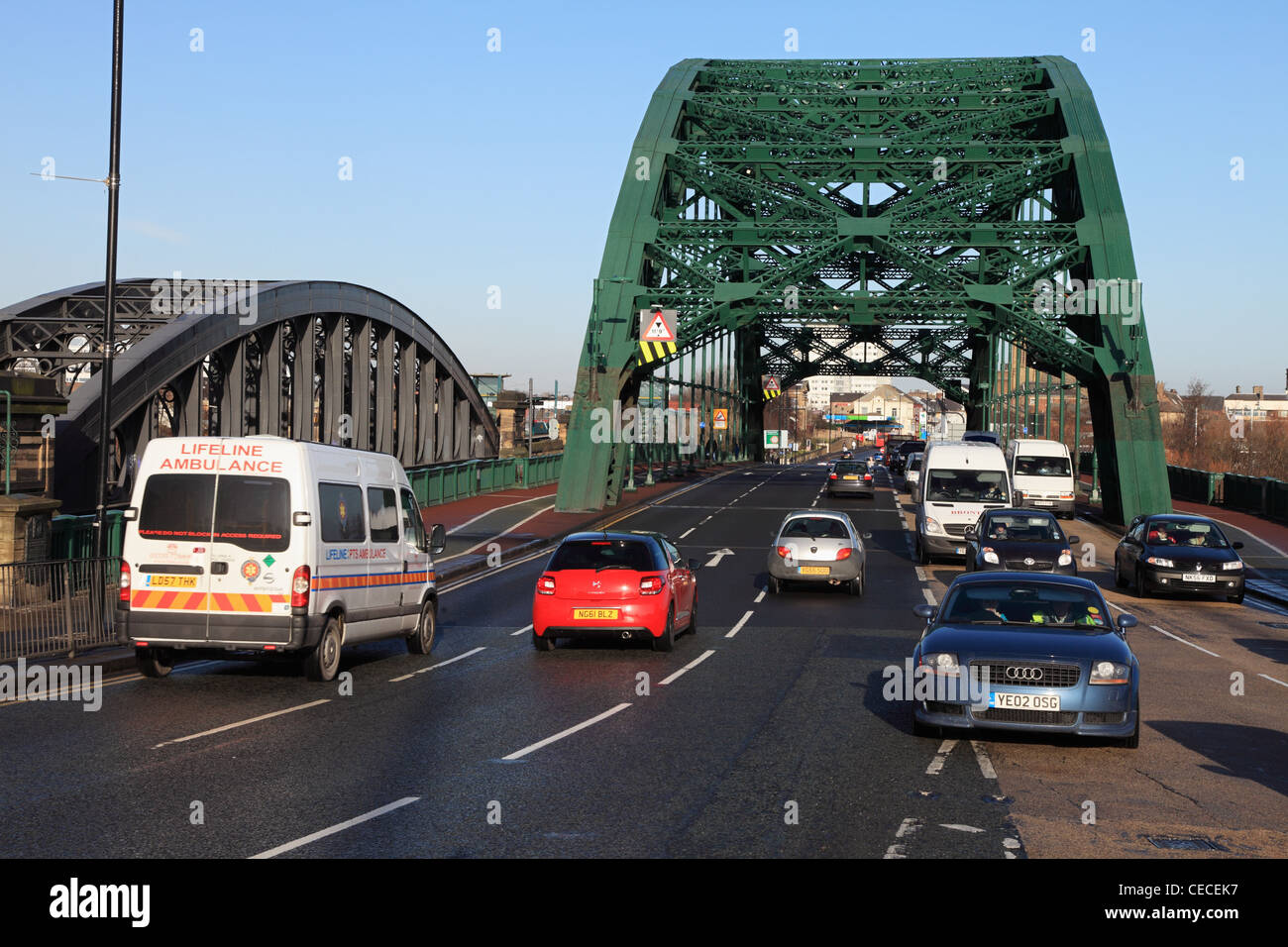 Il traffico che passa su Wearmouth ponte stradale con il ponte ferroviario in background Sunderland North East England Regno Unito Foto Stock