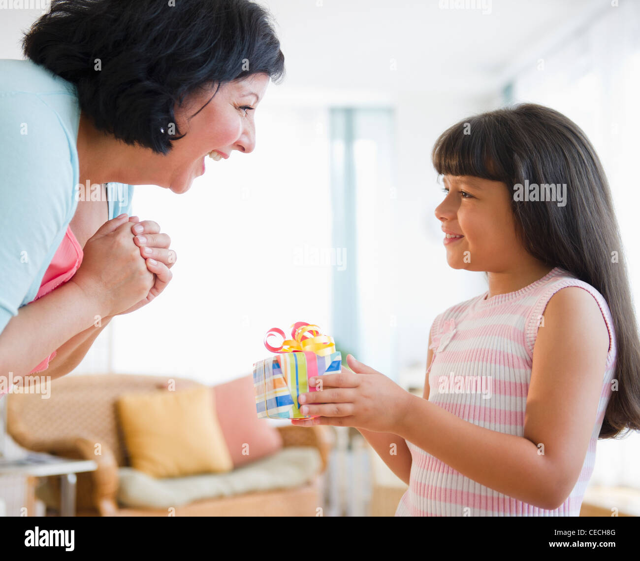 Ragazza ispanica dando la sua madre regalo di compleanno Foto Stock