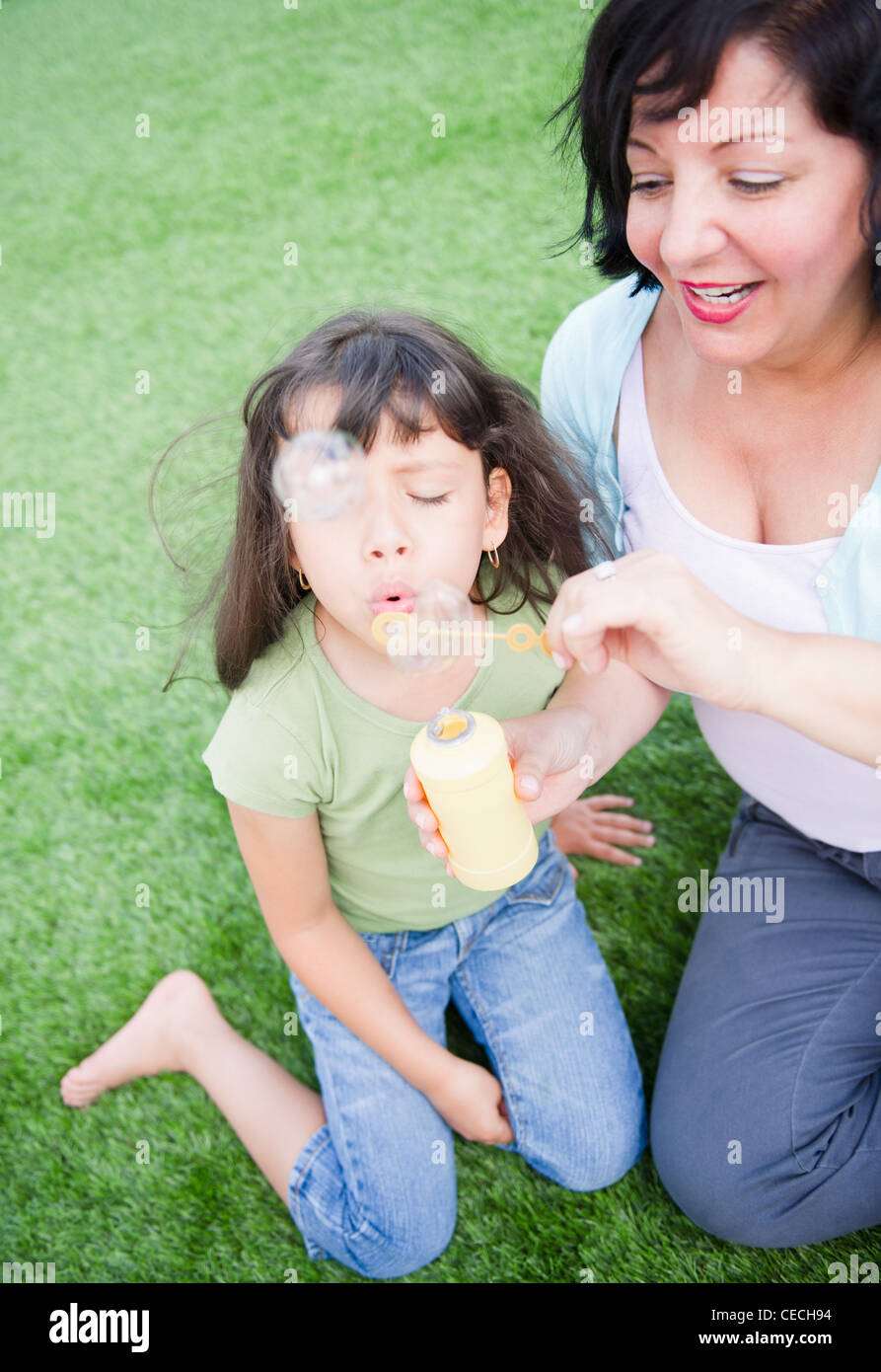 Ispanico madre e figlia a soffiare bolle Foto Stock