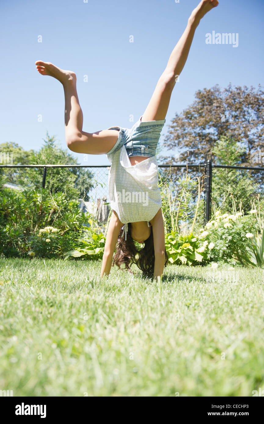 Ragazza ispanica facendo cartwheels in erba Foto Stock