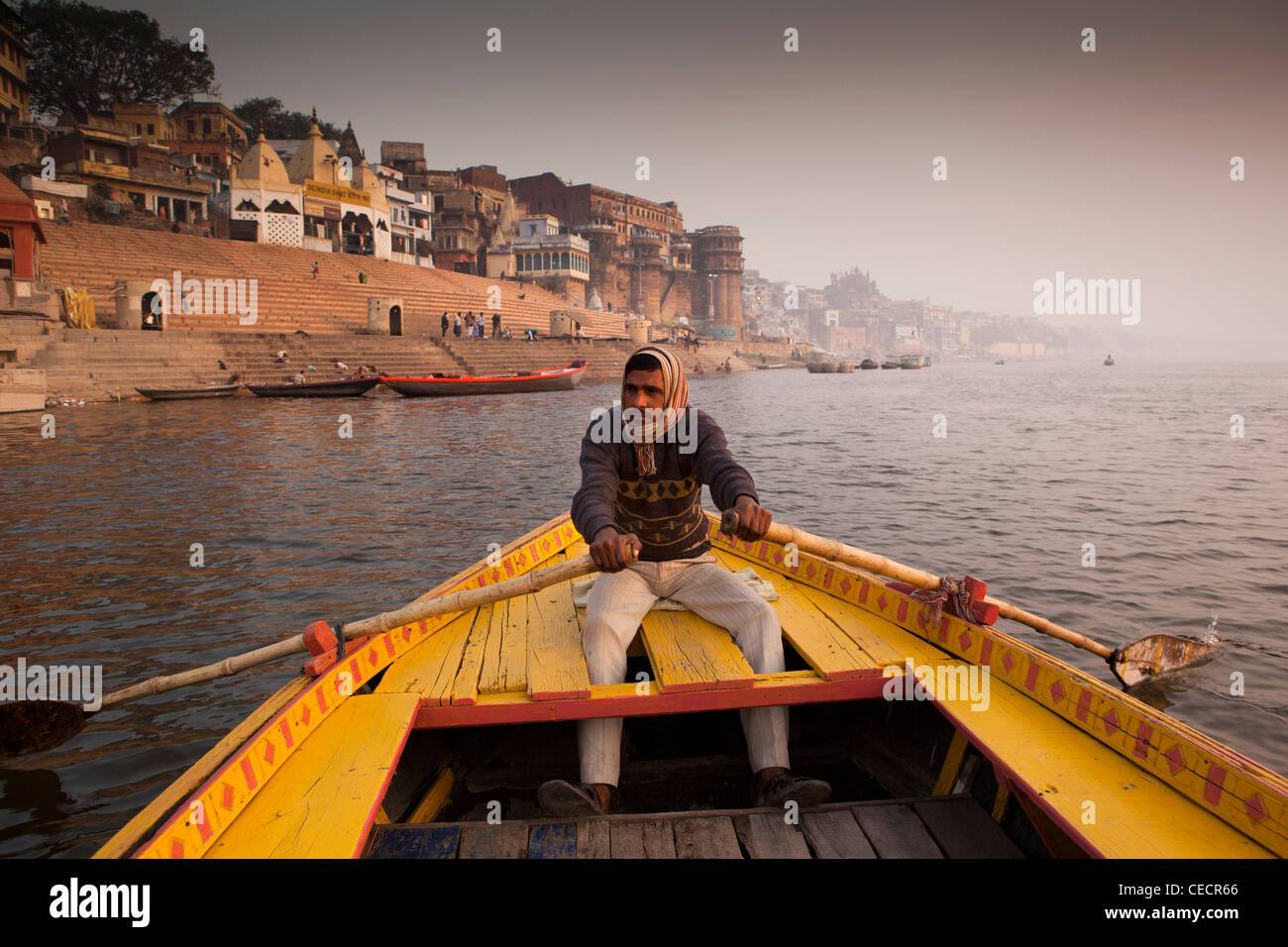 India, Uttar Pradesh, Varanasi, uomo barca a remi di prendere i turisti su alba tour sul Fiume Gange Foto Stock