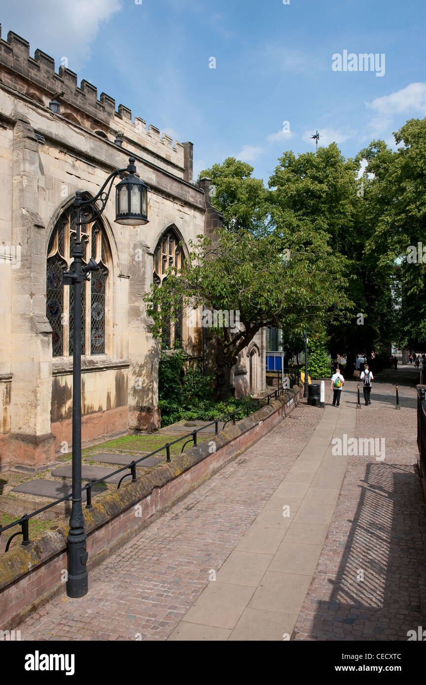 Passaggio pedonale acciottolata a fianco di una chiesa nel centro storico della città di Coventry, West Midlands, Inghilterra. Foto Stock