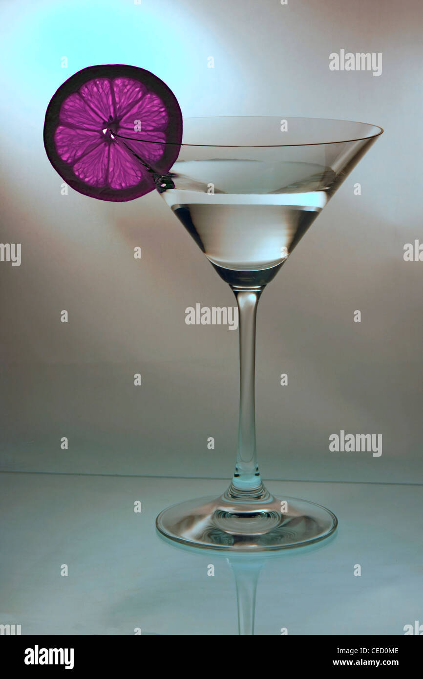 Un coloried fetta di limone sul bordo di un bicchiere da cocktail Foto Stock
