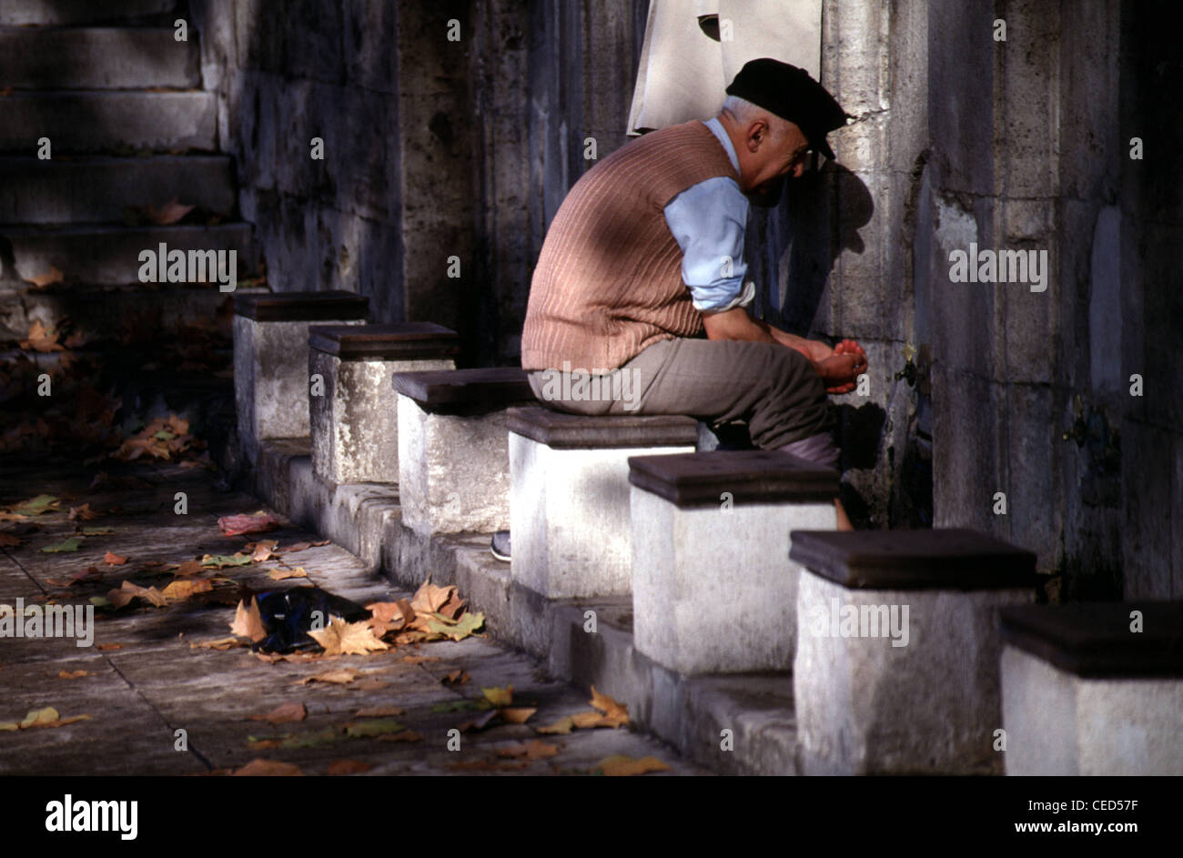 Un uomo musulmano lavarsi le mani e i piedi prima di preghiera di Fatih cami mosque Istanbul Turchia Foto Stock
